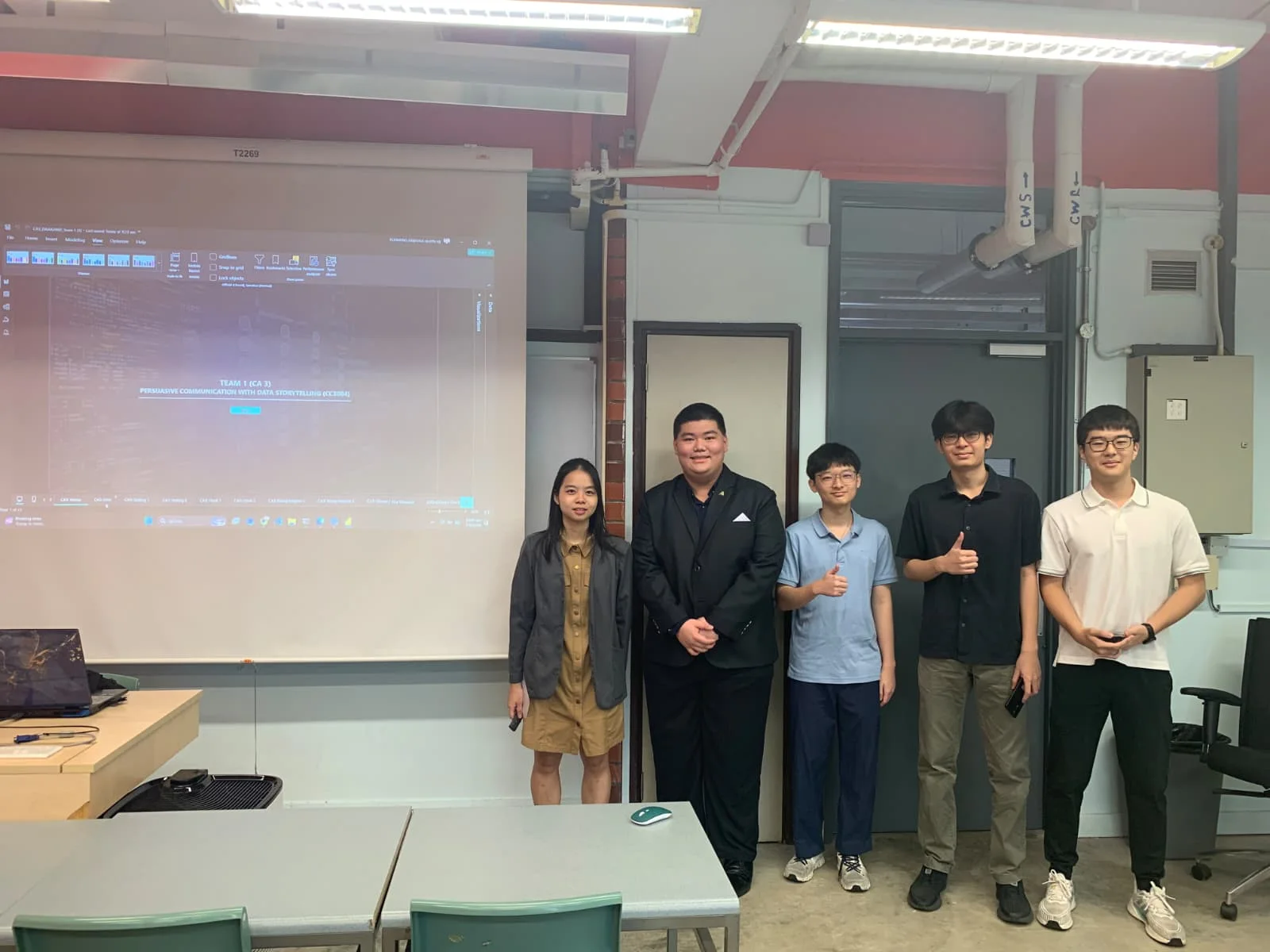A classroom group beside a data-storytelling presentation.