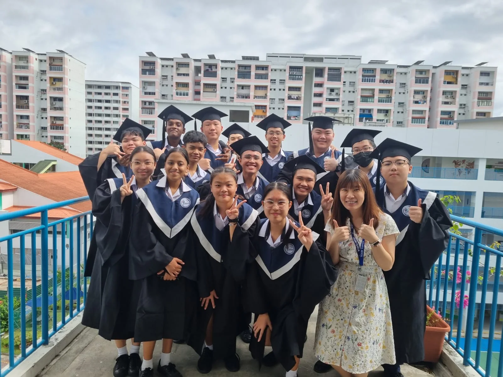 A Yuhua Secondary School group photograph in school-leaving gowns.