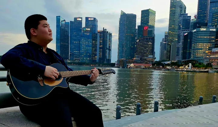 A guitar moment beside the waterfront, from Kun Ming’s personal gallery.