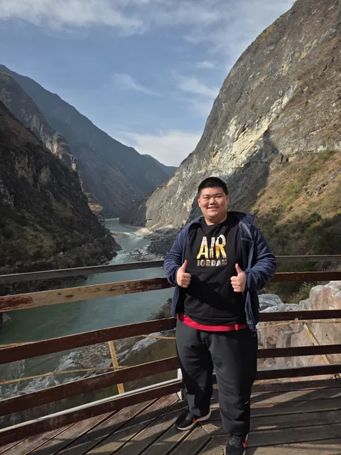 A personal travel portrait beside a river running through a mountain gorge.