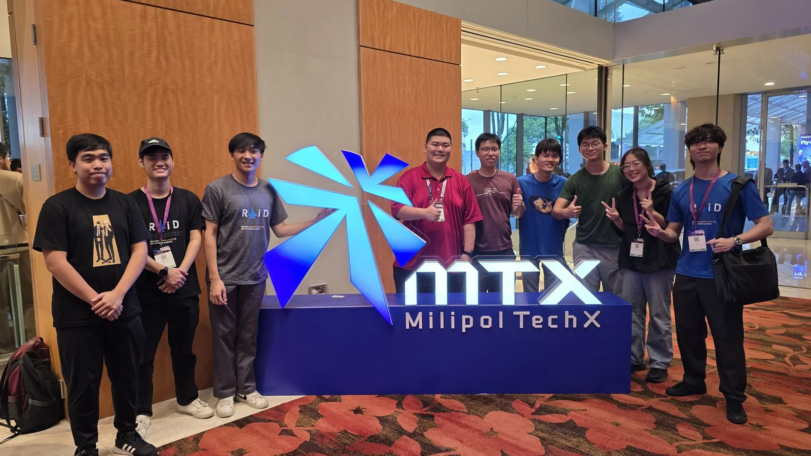 Group photo beside the MilipolTechX event sign.
